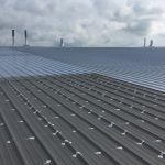 Grandes toitures métalliques - Travaux de protection et finition en cours sur grandes toitures métalliques en Estrie